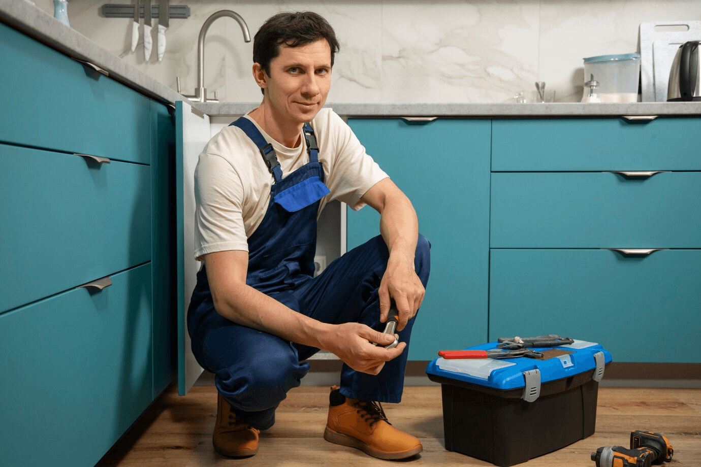 a plumber kneeling and smiling at the camera